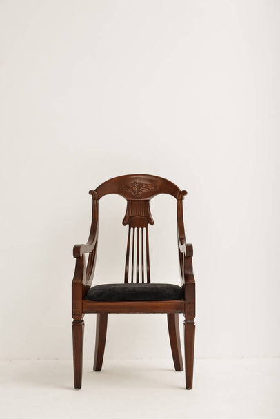 Элегантный деревянный стул возле светлой стены - Фото, изображение