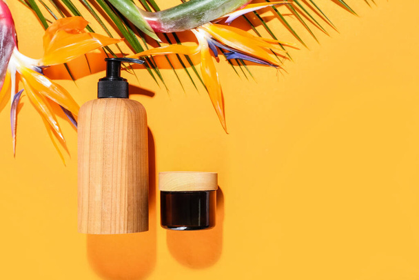 Cosmetic products and strelitzia flowers on color background - 写真・画像