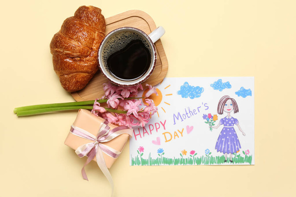 Obrázek s textem Šťastný den matek, květiny, dárek, šálek kávy a croissant na béžovém pozadí - Fotografie, Obrázek