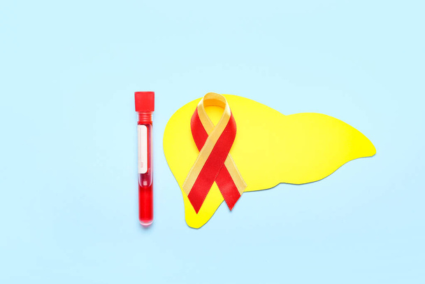 Awareness ribbon with paper liver and blood sample on blue background. Hepatitis concept - Foto, afbeelding