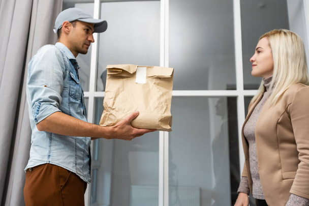 View of a Delivery man handing over a parcel to customer - Foto, Bild