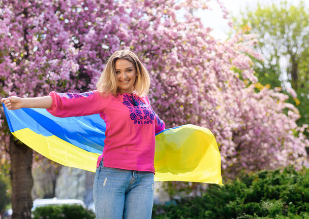 Beautiful blonde hair girl holds the flag of Ukraine  - Zdjęcie, obraz