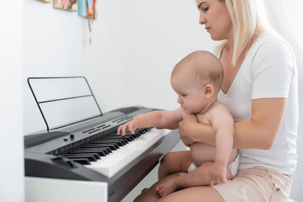Menina e sua mãe tocando piano
 - Foto, Imagem