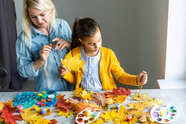 Mother And Daughter Making Autumn Decoration At Home - Photo, Image
