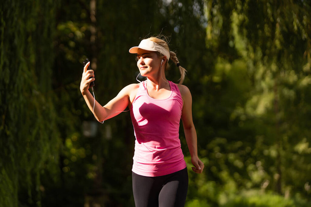 Une femme qui court. Jogging de coureuse pendant l'entraînement en plein air dans un parc. - Photo, image