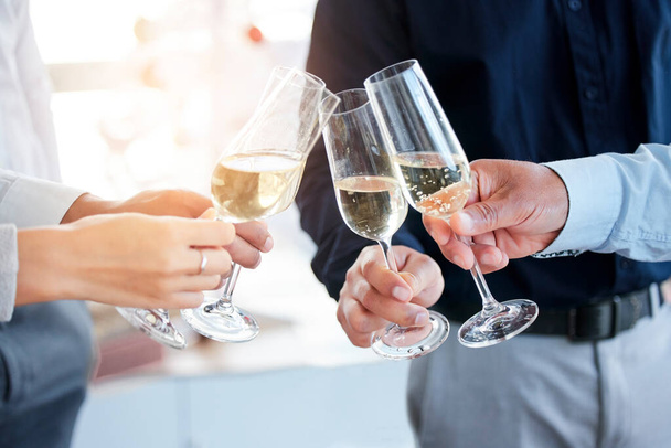 Lets toast to success. Shot of a group of unrecognizable people toasting with wine glasses. - Foto, Bild