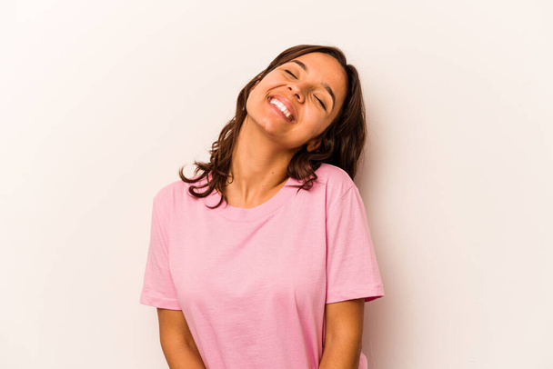 Young hispanic woman isolated on white background relaxed and happy laughing, neck stretched showing teeth. - 写真・画像