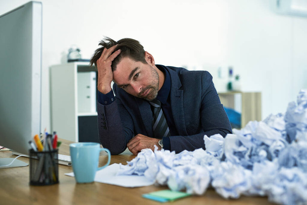 Work just keeps piling up. Shot of a stressed out businessman sitting at his desk overwhelmed by paperwork. - Zdjęcie, obraz