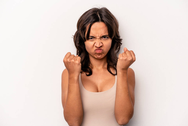 Young hispanic woman isolated on white background showing fist to camera, aggressive facial expression. - Foto, Imagen