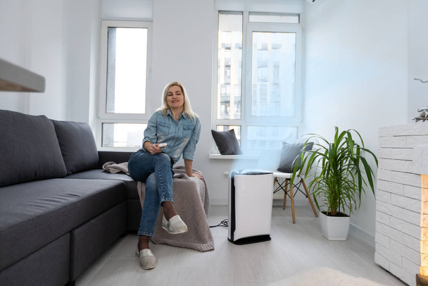 attractive woman with air purifier on windowsill - Photo, Image