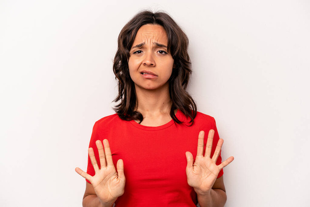 Young hispanic woman isolated on white background rejecting someone showing a gesture of disgust. - Photo, Image