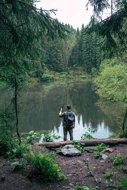ισχυρός άνθρωπος πεζοπόρος κοιτάζοντας βουνό λίμνη ταξίδια έννοια αντίγραφο χώρο - Φωτογραφία, εικόνα