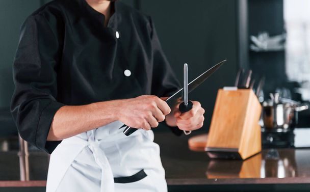 Professional young chef cook in uniform standing and preparing for the work on kitchen. - 写真・画像