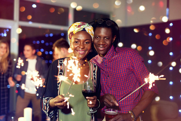 Deja que tus celebraciones brillen de alegría. Retrato de una atractiva pareja joven divirtiéndose con bengalas en un club nocturno. - Foto, Imagen