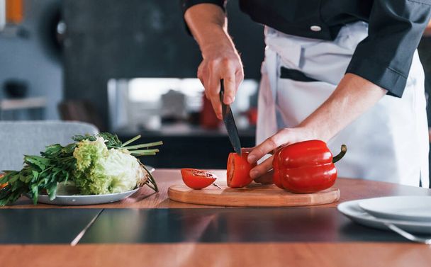 Professional young chef cook in uniform making salad on the kitchen. - 写真・画像