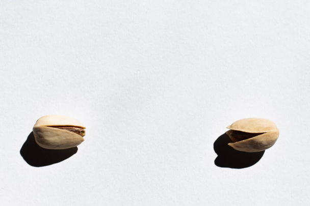 flat lay of two cracked pistachios on white background  - Photo, Image