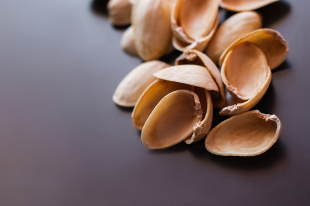 close up view of shells form pistachio nuts on black  - Foto, Bild