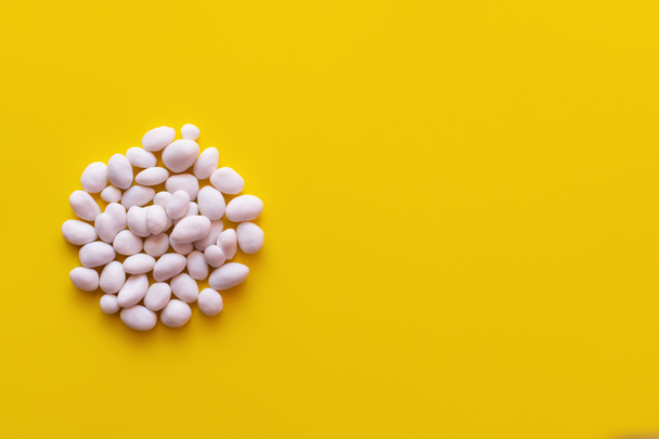 top view of pile with peeled pine nuts on yellow background - Photo, Image