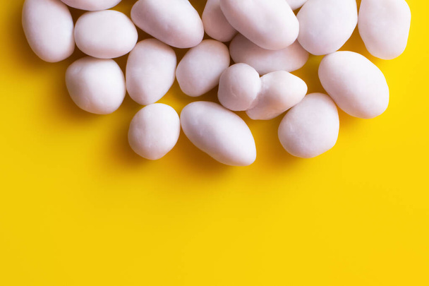 close up view of peeled pine nuts on yellow background - Foto, Imagen