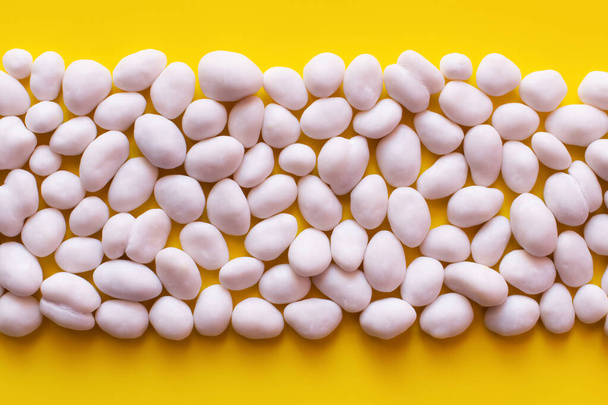 flay lay with row of peeled pine nuts on yellow background - 写真・画像