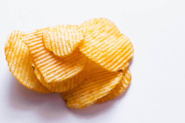 close up view of wavy and salty potato chips on white - Foto, Imagen