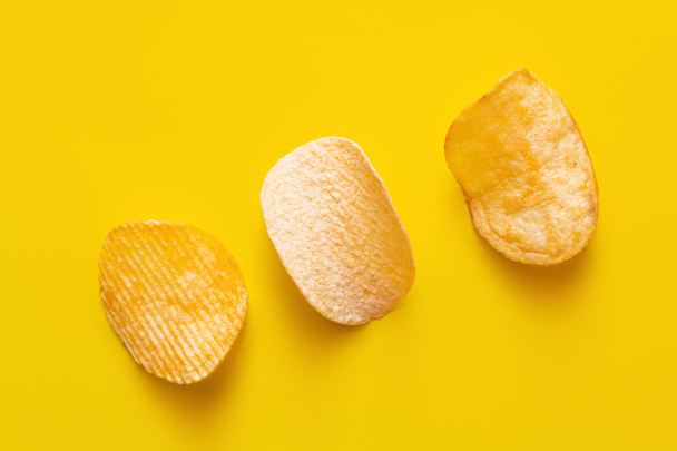 top view of different salty potato chips on yellow - Foto, Bild