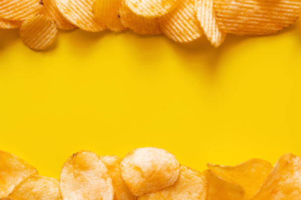 flay lay view of different salty and wavy potato chips on yellow - 写真・画像