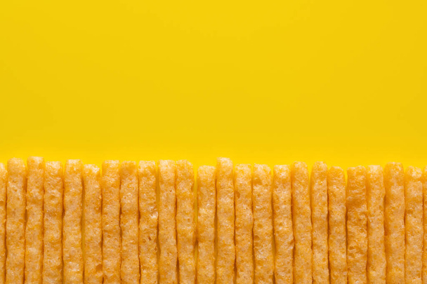 黄色の上においしいと塩辛いフランスのフライドポテトの平らなレイアウト - 写真・画像