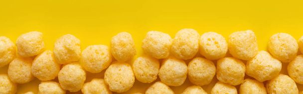 top view of puffed and tasty cheese pops on yellow, banner - Fotografie, Obrázek