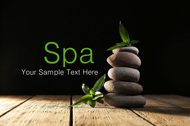 Spa stones and bamboo on wooden table on dark background - Foto, immagini