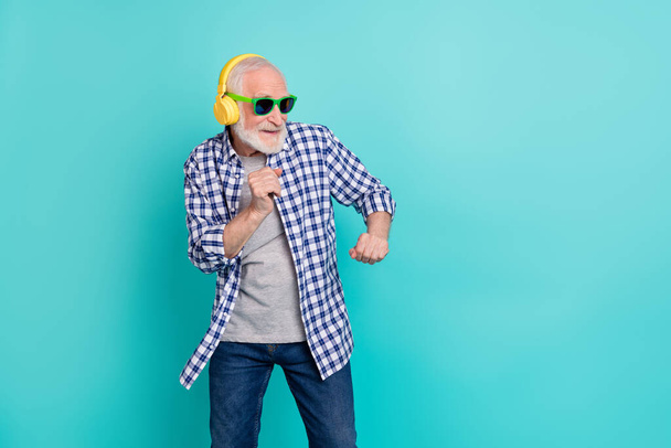 Portrait of positive cheerful granddad enjoy dancing wireless headphones isolated on teal color background - Foto, afbeelding