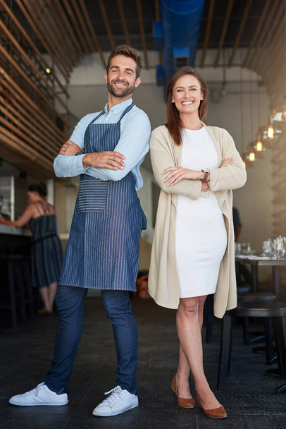 Running their business empire together. Portrait of two young business owners standing in their cafe. - Foto, imagen