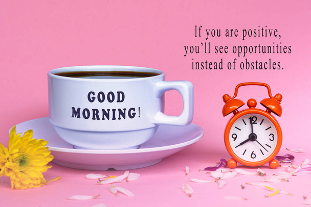 Мотиваційна цитата з чашкою білої кави з будильником, встановленим о восьмій годині - Доброго ранку, якщо ви позитивні ви бачите можливості замість перешкод
. - Фото, зображення