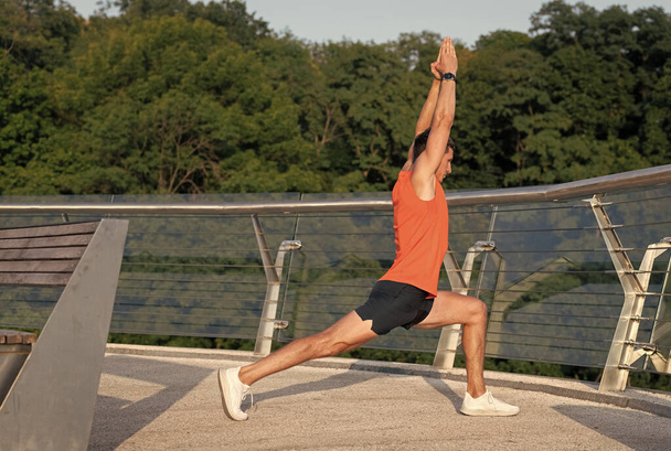 Fit man hold virabhadrasana pose doing crescent lunge stretch on promenade, yoga - Foto, Imagen