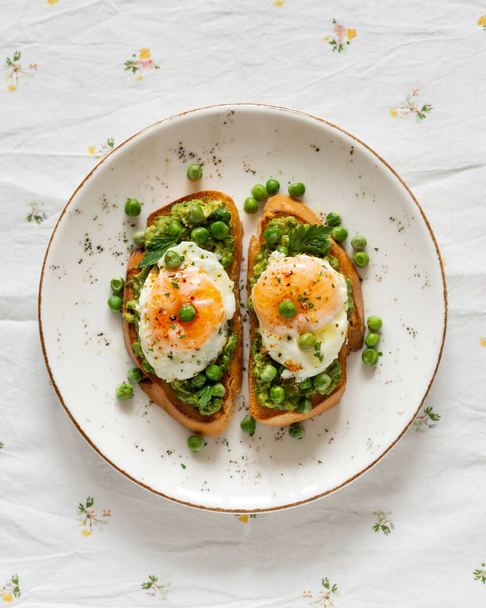 Toasts with green peas and eggs on a concrete background. Homemade healthy pea toast  - Foto, afbeelding