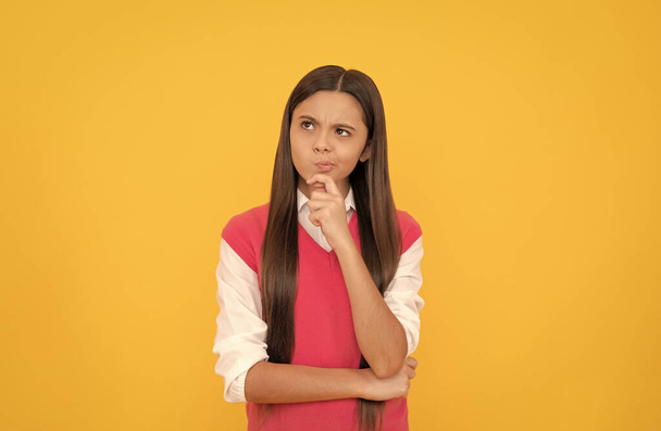 thinking teen school girl with long hair on yellow background, decision - Photo, Image