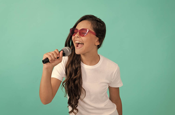 Jó karaokézást! Karaoke gyermek énekes kék háttér. Happy gyerek énekel a mikrofonba. zene. - Fotó, kép