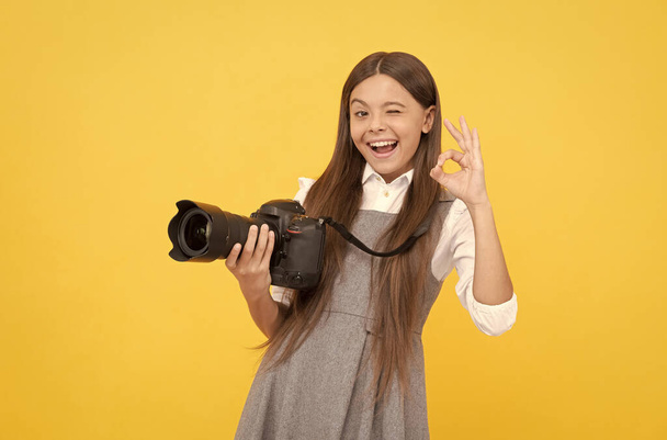fröhliche Kind Mädchen nehmen Foto mit Digitalkamera zeigen ok Geste, Fotografie - Foto, Bild