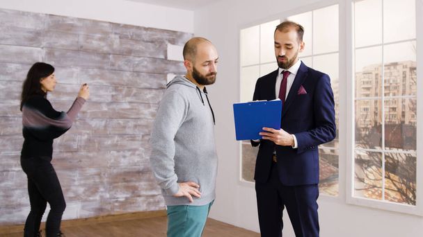 Real estate agent in business suit describes apartment to client - Photo, Image