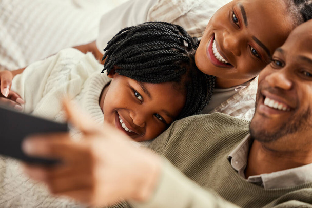Tworzenie wspomnień po jednym selfie. Zdjęcia młodej rodziny robiącej selfie w domu. - Zdjęcie, obraz