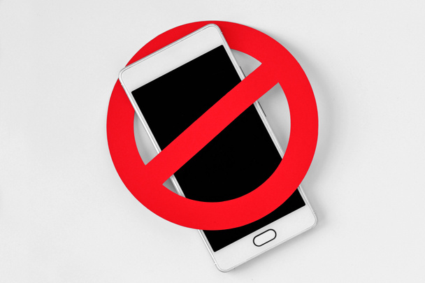 Teléfono móvil con señal de prohibición sobre fondo blanco - No hay concepto de teléfono móvil - Foto, imagen