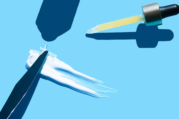 Pipette with dose of fluid hyaluronic acid on blue background. cosmetic concept. flat lay. Place for tex - Photo, Image