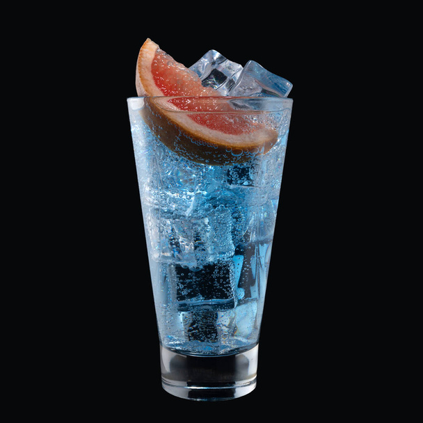 Cóctel laguna azul con licor Blue Curacao en un vaso alto aislado sobre fondo negro. Cóctel alcohólico clásico - Foto, Imagen