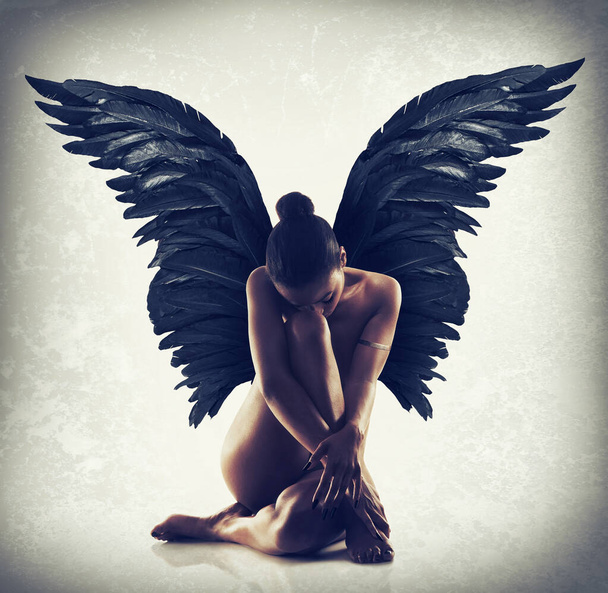 Gelassenheit in der Stille. Aufnahme einer nackten Frau mit hinter ihrem Rücken ausgebreiteten Flügeln. - Foto, Bild