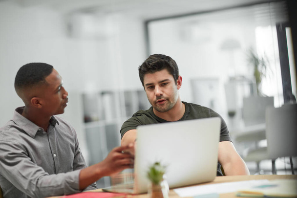 Colaborações que produzem resultados. Tiro de dois jovens empresários usando um laptop durante uma reunião em um escritório moderno. - Foto, Imagem