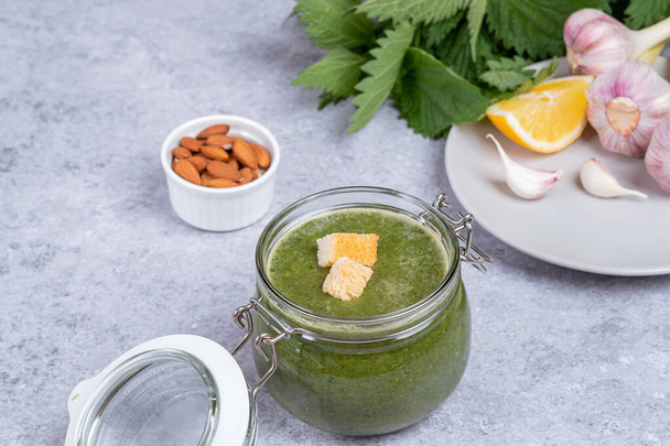 Nettle soup made from young shoot. In a glass jar nettle, garlic, almond, lemon juice, oil and decorated with croutons. space for text. High quality photo - Photo, image