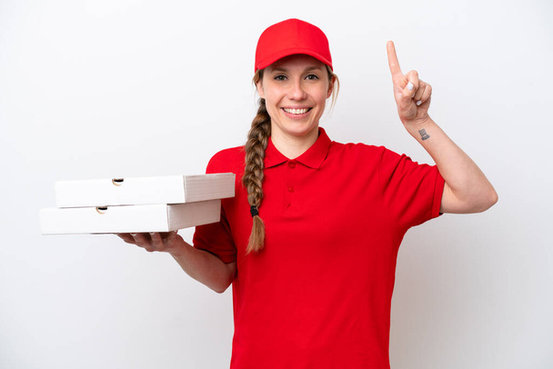 pizza delivery woman with work uniform picking up pizza boxes isolated on white background pointing up a great idea - Zdjęcie, obraz