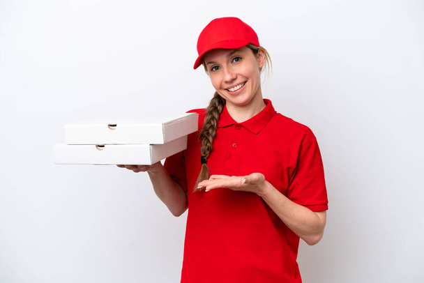 жінка з доставкою піци з робочою формою, збираючи коробки для піци ізольовані на білому тлі, розтягуючи руки на бік, щоб запросити прийти
 - Фото, зображення