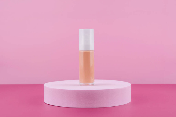 Cosmetic liquid foundation nude cream bottle mockup on round podium pedestal. Beige concealer base cosmetics product mock up on pink background. Skincare beauty primer, bb corrector - Photo, Image