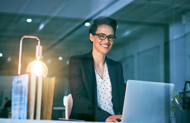 Seule l'ambition vous mènera au sommet. Portrait d'une femme d'affaires confiante travaillant sur un ordinateur portable dans un bureau la nuit. - Photo, image